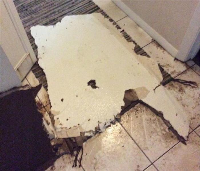 Piece of fallen ceiling on the floor of a hallway.
